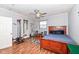 Comfortable bedroom with hardwood floors, a ceiling fan, and an ensuite bathroom with a shower at 202 Rainbow Blvd, Indianapolis, IN 46234