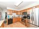 Functional kitchen featuring stainless steel appliances, wood cabinetry, and durable countertops at 202 Rainbow Blvd, Indianapolis, IN 46234