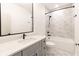 Bathroom with marble-style tile, bathtub and shower, gray vanity, and matte black hardware at 2051 Columbia Ave, Indianapolis, IN 46202