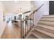 Open-concept living space with wood floors, kitchen island, and staircase with black iron railing at 2051 Columbia Ave, Indianapolis, IN 46202