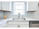 Close up on kitchen sink with new faucet, white cabinets and bright window at 2361 Southeastern Ave, Indianapolis, IN 46201