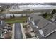 Wide aerial view of townhouses with well-kept roofs, green spaces, and a commercial complex in the background at 256 Strand Ln # Apt C, Avon, IN 46123
