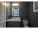 Stylish powder room with dark blue walls, vanity with modern sink and lit mirror at 256 Strand Ln # Apt C, Avon, IN 46123