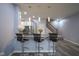 Kitchen bar area with granite countertop, three bar stools, pendant lighting, and wood flooring at 256 Strand Ln # Apt C, Avon, IN 46123