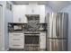 Modern kitchen has white cabinets, stainless steel appliances, and black marble backsplash at 256 Strand Ln # Apt C, Avon, IN 46123