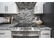 Modern kitchen details black marble backsplash with stainless steel appliances and cooktop oven at 256 Strand Ln # Apt C, Avon, IN 46123