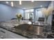 Modern kitchen boasts marble countertop island with stainless steel sink and faucet and view to living area at 256 Strand Ln # Apt C, Avon, IN 46123