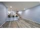 Open-concept living area with wood flooring, kitchen bar with stools, and staircase to the upper level at 256 Strand Ln # Apt C, Avon, IN 46123