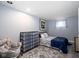 Cozy bedroom with light blue walls, area rug, storage, a comfortable chair, and a window at 3334 Eden Village Pl, Carmel, IN 46033