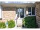 Welcoming front entrance with decorative glass door, brick accents, and meticulously landscaped greenery at 3334 Eden Village Pl, Carmel, IN 46033