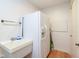 Practical laundry room featuring a utility sink and a white refrigerator, providing essential space for cleaning and storage needs at 3334 Eden Village Pl, Carmel, IN 46033