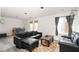 Bright living room featuring a dark leather couch, rustic coffee table, and an area rug at 3334 Eden Village Pl, Carmel, IN 46033