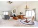 Open-concept living room with high vaulted ceiling, a fireplace, and natural light, perfect for gatherings at 3334 Eden Village Pl, Carmel, IN 46033