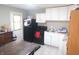 Functional kitchen featuring white cabinets, black appliances, and a view of an adjacent dining space at 4502 W 36Th St, Indianapolis, IN 46222