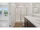 Bathroom features a double sink, vinyl flooring, walk-in shower, and a view to the bedroom at 4712 E Shadowbrook Dr, Camby, IN 46113