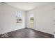 Bright bedroom featuring gray wood-look flooring, white walls, and a door to the outside at 4712 E Shadowbrook Dr, Camby, IN 46113