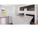 Modern kitchen featuring an island, stainless steel sink, white countertops, and dark cabinets at 4712 E Shadowbrook Dr, Camby, IN 46113