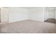 Spacious living room with neutral carpeting, bright white walls, and a hallway leading to the home entrance at 4712 E Shadowbrook Dr, Camby, IN 46113