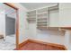 Bright closet design features built-in shelves, rods, and wood trim adjacent to the bathroom with tub and shower at 528 Wind Skip Cir, Westfield, IN 46074