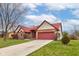 A single-Gathering, one story brick home with red roof and well-manicured lawn with an attached two-car garage at 528 Wind Skip Cir, Westfield, IN 46074
