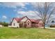 A single-Gathering, one story brick home with red roof and well-manicured lawn with an attached two-car garage at 528 Wind Skip Cir, Westfield, IN 46074