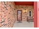 Inviting covered front porch with brick walls, bench, lantern, and glass paneled front door at 528 Wind Skip Cir, Westfield, IN 46074