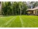 Large backyard with a covered patio, wrought iron fence, and lush, manicured lawn at 552 E 82Nd St, Indianapolis, IN 46240