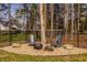 Backyard fire pit area with Adirondack chairs, rock accents, and partial fencing at 552 E 82Nd St, Indianapolis, IN 46240