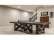 A beautifully finished basement featuring a ping pong table, elegant staircase, and wooden furniture at 552 E 82Nd St, Indianapolis, IN 46240