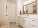 Bathroom with white vanity, framed mirror, marble counters, seating, and an entry door at 552 E 82Nd St, Indianapolis, IN 46240