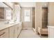 Bright bathroom features a double vanity with marble counters and a glass enclosed shower at 552 E 82Nd St, Indianapolis, IN 46240