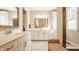 A view of the bathroom with double vanity, marble counters, framed mirrors, and seating at 552 E 82Nd St, Indianapolis, IN 46240