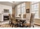 Sunlit dining area featuring a fireplace, large windows, a wooden table, and upholstered chairs at 552 E 82Nd St, Indianapolis, IN 46240