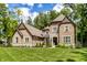 Spacious brick home with stone accents, beautiful landscaping, and a lush green lawn at 552 E 82Nd St, Indianapolis, IN 46240