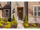 Inviting front entrance with stone facade, decorative wreath and beautiful landscaping at 552 E 82Nd St, Indianapolis, IN 46240