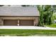 Attached two-car garage with brick exterior, ample parking space, and exterior carriage lights at 552 E 82Nd St, Indianapolis, IN 46240