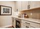 Modern kitchen features a built-in wine fridge, white cabinets, and stone countertops at 552 E 82Nd St, Indianapolis, IN 46240