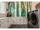 Well-lit laundry room featuring a modern washer/dryer set and ample cabinet space at 552 E 82Nd St, Indianapolis, IN 46240