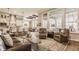 Open-concept living room with large windows and a view of the modern kitchen and dining area at 552 E 82Nd St, Indianapolis, IN 46240