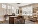 Well-lit home office with large desk and comfortable seating area, with an exterior view at 552 E 82Nd St, Indianapolis, IN 46240