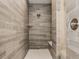 A modern shower with wood-look tiling, glass door, and a rainfall shower head at 552 E 82Nd St, Indianapolis, IN 46240
