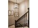 Elegant staircase with decorative wall paneling, stylish light fixture, and framed artwork at 552 E 82Nd St, Indianapolis, IN 46240
