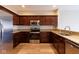 Well-lit kitchen showcasing dark cabinets, stainless steel appliances, and beautiful granite countertops at 5786 Blue Sky Dr, Whitestown, IN 46075