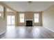 Open living room with fireplace, natural light, and gray wood-look floors at 5786 Blue Sky Dr, Whitestown, IN 46075