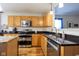 A spacious kitchen with stainless steel appliances, granite counters, wood cabinets, and hardwood floors at 5846 Edgewood Trace Blvd, Indianapolis, IN 46239