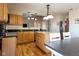 Bright kitchen boasts stainless appliances, wood cabinetry, hardwood floors, and an island with granite countertops at 5846 Edgewood Trace Blvd, Indianapolis, IN 46239