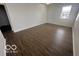 Open living room area featuring neutral paint and plank flooring and natural light from a window at 639 Rocky Meadow Dr, Greenwood, IN 46143