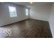 Open living room area featuring neutral paint and plank flooring and natural light from two windows at 639 Rocky Meadow Dr, Greenwood, IN 46143