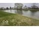 Scenic community pond with a grassy bank and neighboring houses at 639 Rocky Meadow Dr, Greenwood, IN 46143