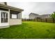 Spacious backyard with green grass, wooden fence, and a screened-in porch for enjoying the outdoors at 647 Albermarle Dr, Pittsboro, IN 46167
